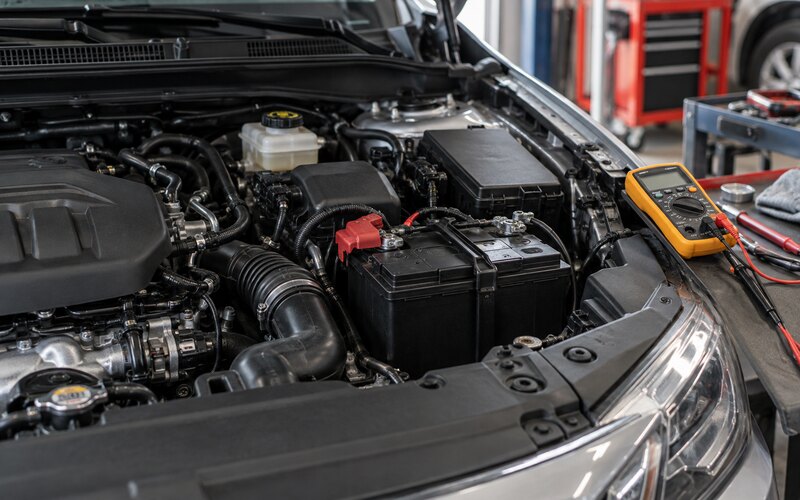 Motor bölümünde kontrol edilen otomobil aküsü